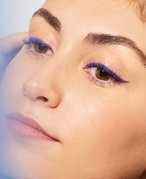 person wearing purple winged eyeliner