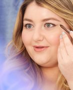 A closeup of someone applying brown eyeliner for a brown eyeliner look