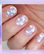 hand with cloud nail art on nails