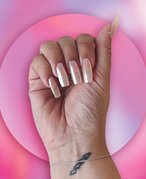 Picture of an editor with neutral chrome nails on a pink graphic gradient background