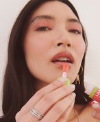 person applying glossy lip balm