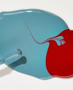 Two puddles of red and blue nail polish stains on a white surface