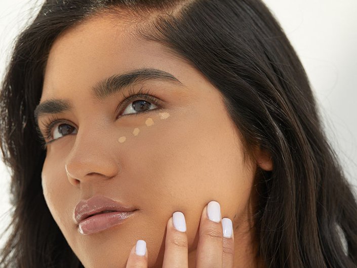 Picture of a model with four dots of concealer underneath their eyes