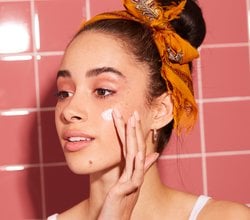 Photo of a person applying cream to their cheek