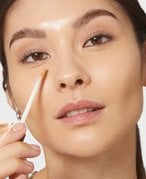 Photo of a person applying makeup to face with makeup sponge