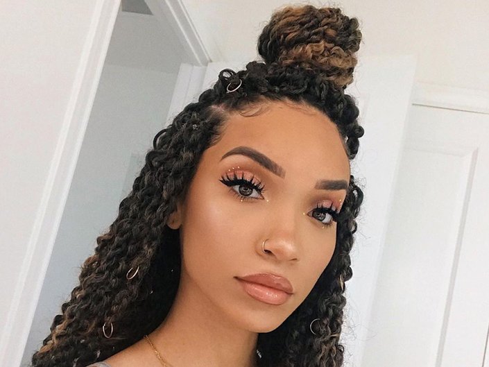 Person with hair styled in passion twists in a half-up, half-down bun