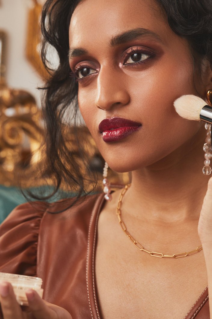 person applying makeup to cheek