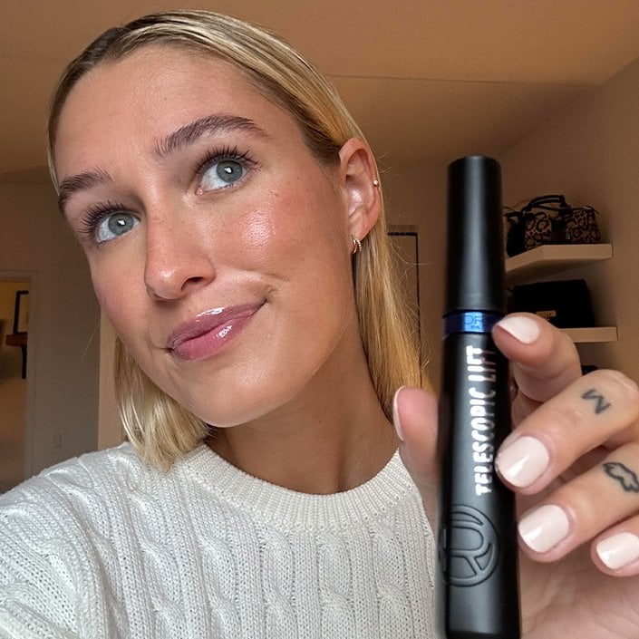 Editor wearing and holding up the L’Oréal Paris Telescopic Lift Washable Color Mascara in Stellar Blue