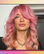 A pink, orange and yellow gradient background with a picture of a person with pink wavy hair.