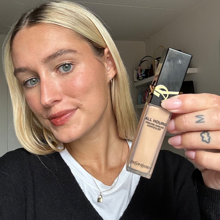 Jordan wearing and holding up the YSL Beauty All Hours Creaseless Precise Angles Concealer in MN1