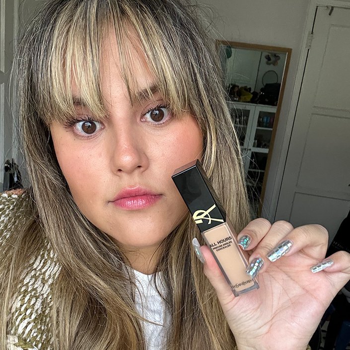 Reece wearing and holding up the YSL Beauty All Hours Creaseless Precise Angles Concealer in MN1